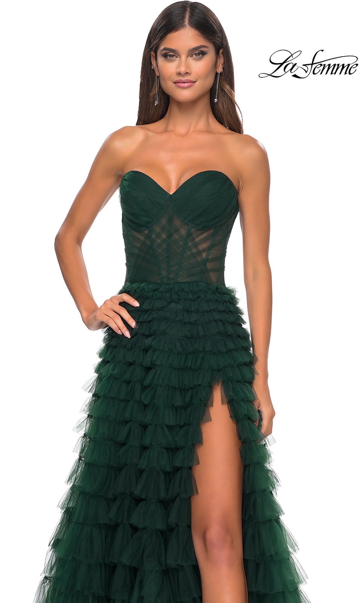 Woman in the La Femme Strapless Long Ruffled Prom Dress 32283, a dark green tulle gown with a sheer bodice, layered ruffle skirt, and high slit; La Femme logo appears in the top right corner.